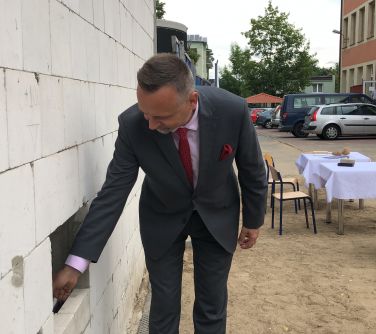 Burmistrz dokłada zaprawę murarską przy kamieniu węgielnym