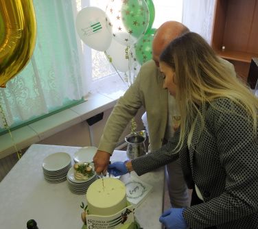 Dyrektor Studium z pomocą współpracowniczki kroją tort