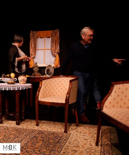 dwoje aktorów na scenie, scenografia przedstawiająca salon