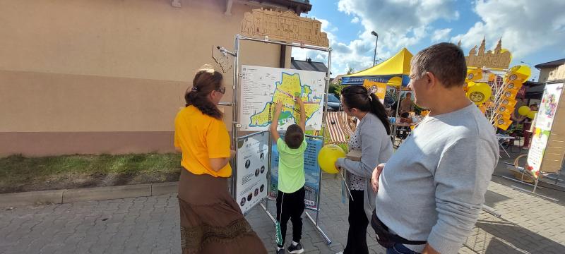 projekt "Mińsk na kółkach", wystawa mobilna, dziecko przyczepiające magnesy na tablice