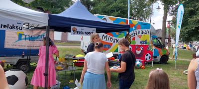 osoby uczestniczące w zajęciach sportowych, w tle kolorowy bus