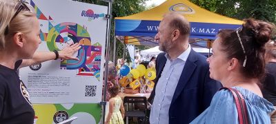 prezentacja muralu osoba opowiadająca po lewej, po prawej dwie osoby słuchające