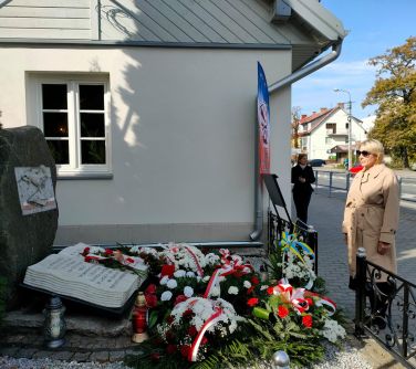 Kierownik Wydziału Promocji, Kultury i Sportu przed pomnikiem ZNP