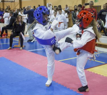 Walka zawodniczek karate na macie.
