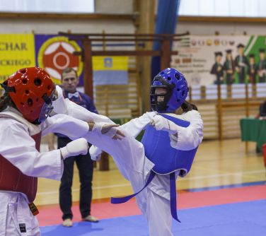 Walka zawodniczek karate na macie.