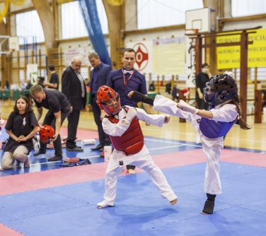 Walka zawodniczek karate na macie.