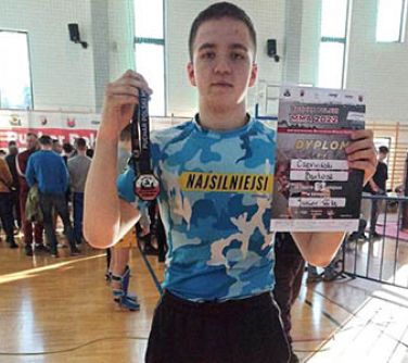 Zawodnik prezentuje brazowy medal, który zdobył na Pucharze Polski MMA.