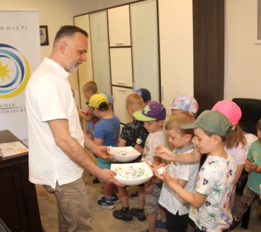 Burmistrz Miasta rozdaje dzieciom cukierki