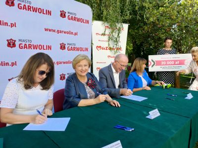 osoby siedzące przy stole podpisujące umowę na dofinansowanie zadania "Aktywizacja seniorów w mieście Mińsk Mazowiecki"