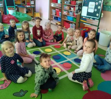 grypa przedszkolaków siedzi na dywanie