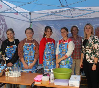 uśmiechnięte uczennice w namiocie szkoły w towarzystwie dwóch osób dorosłych