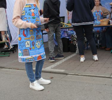 dziewczynka w fartuszku z tabletem w rękach