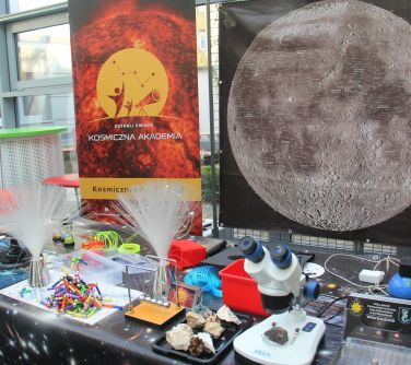 stół z przyrządami astronomicznymi, w tle plakat z księżycem