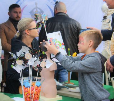 chłopiec ogląda stoisko wystawowe jednej ze szkół