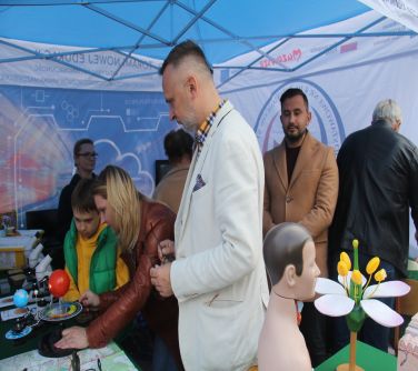 ludzie w namiocie jednej ze szkół oglądający prezentowane przedmioty