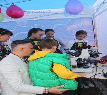 ludzie w namiocie jednej ze szkół oglądający prezentowane przedmioty
