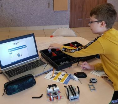 Chłopiec w ławce obsługujący program do robotyki