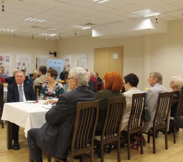 goście jubileuszu siedzacy przy stołach