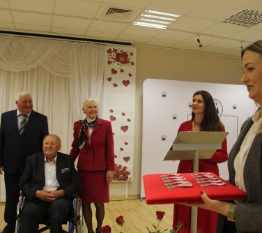 kobieta trzymajaca wręczane medale, w tle goście jubileuszu