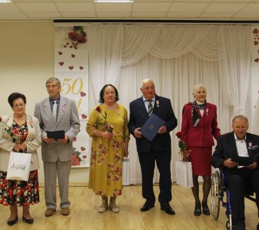 odznaczone małżeństwa pozują do zdjecia z burmistrzem i zastępczynią burmistrza