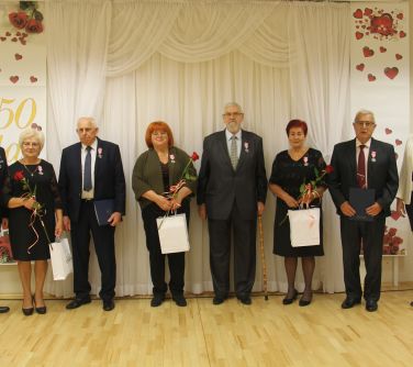 odznaczone małżeństwa pozują do zdjecia z burmistrzem i zastępczynią burmistrza