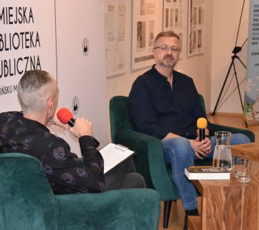 dwaj mężczyżni rozmawiajacy podczas spotkania autorskiego