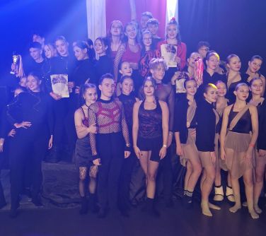 liczna grupa tancerzy pozuje do zdjęcia na podium