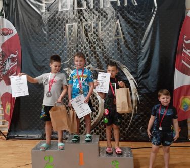 czterej chłopcy pozują do zdjęcia stojąc na podium