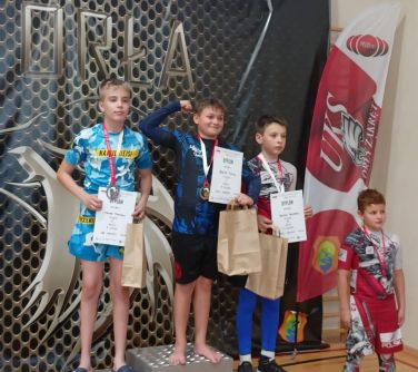 czterej chłopcy pozują do zdjęcia stojąc na podium