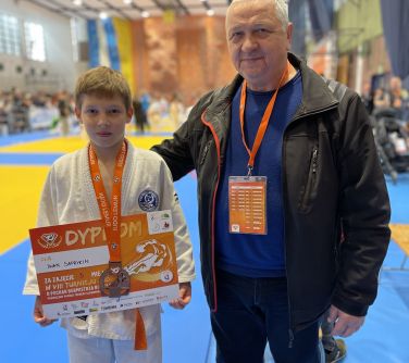zawodnik pozuje do zdjęcia z trenerem