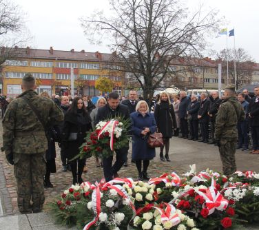 dyrektorzy szkół składają wiązankę pod pomnikiem niepodległości
