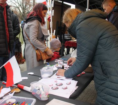 kobieta przygotowująca przypinki dla mieszkańców