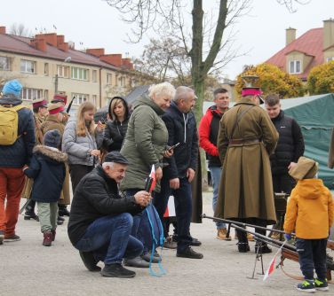 męzczyzna wykonujący zdjęcia dziecku przy namiocie 7 Pułku Ułanów Lubelskich