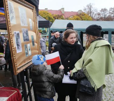 kobiety rozmawiające przy tablicy ze zdjęciami