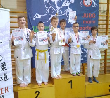 chłopcy w komonach stoją na podium