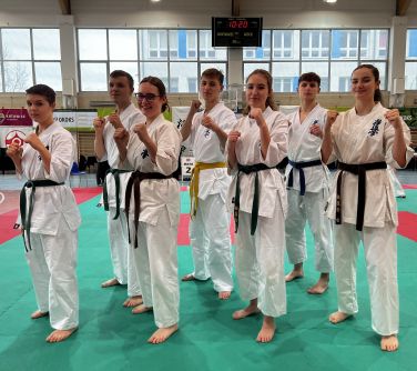 grupa młodych karateków w kimonach pozuje do zdjęcia