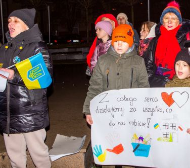 ludzie śpiewają, dwóch chłopców trzyma transparent Z całego serca ziękujemy za wszystko co dla nas robicie!