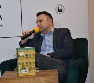 mężczyzna siedzi na fotelu przemawia