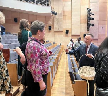 mężczyzna wręcza upominki kobietom na sali