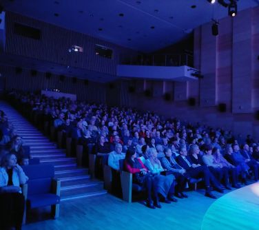 publiczność siedzi w fotelach w miejskiej szkole artystycznej