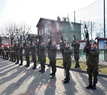 żołnierze strzelają z karabinów, widać dym unorzący się nad karabinami