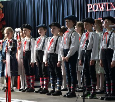 występ dzieci na scenie, dzieci w białych koszulach