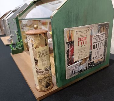 miniaturowa kolumna i ściana z przyklejoną miniaturową gazetą