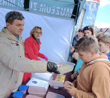 osoby przy stoisku przygotowują sobie herbaty