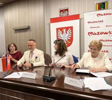 cztery osoby siedzą przy stole