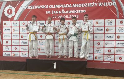 osoby pozuja do zjęcia stojąc na najwyższym stopniu podium