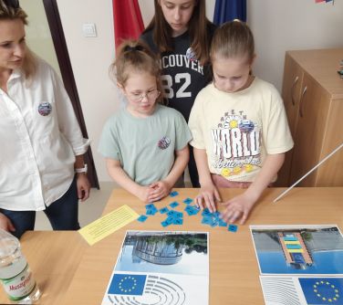 osoby układają puzzle