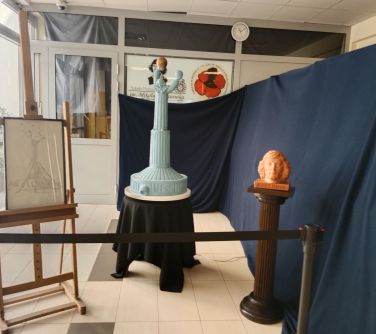 na stole posąg kopernika, obok grantowa płachta