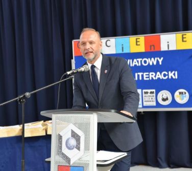 mężczyzna przemawia przy przeźroczystej mównicy
