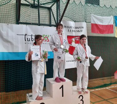 dziewczynki stoją na podium, trzymają dyplomy